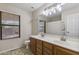 Bright bathroom featuring dual sinks, large mirror, and ample lighting at 10923 E Flower Ave, Mesa, AZ 85208