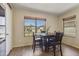 Well-lit dining area with a square table, comfortable seating, and a view of the outdoors at 10923 E Flower Ave, Mesa, AZ 85208