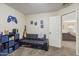 Versatile game room featuring a sofa, TV, guitar, and storage cubes, perfect for relaxation at 10923 E Flower Ave, Mesa, AZ 85208