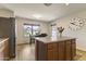 Bright kitchen with a central island, stainless steel refrigerator, and view to breakfast nook at 10923 E Flower Ave, Mesa, AZ 85208