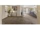 Spacious living room with access to other areas, featuring carpeted floors and natural light at 10923 E Flower Ave, Mesa, AZ 85208