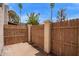 Cozy fenced backyard area with a concrete surface and palm trees visible above the fence at 1208 E Lawrence Ln, Phoenix, AZ 85020
