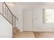 Entryway featuring a staircase with a metal railing and tile and carpet flooring at 1208 E Lawrence Ln, Phoenix, AZ 85020