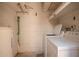 A simple laundry room featuring a washing machine, dryer, water heater, and painted block walls at 1208 E Lawrence Ln, Phoenix, AZ 85020