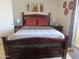 Bedroom featuring a dark wood bed frame with decorative carvings and tiled floors at 12221 W Bell Rd # 209, Surprise, AZ 85378