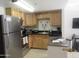 Well-lit kitchen features stainless steel appliances, wood cabinets, and black countertops at 12221 W Bell Rd # 209, Surprise, AZ 85378