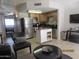 Open kitchen and living area featuring stainless steel appliances and a breakfast bar at 12221 W Bell Rd # 209, Surprise, AZ 85378