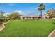 Beautifully landscaped backyard with a large lawn, mature trees, and a sparkling pool, great for relaxing and entertaining at 12821 N 67Th St, Scottsdale, AZ 85254