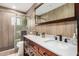 Modern bathroom featuring double sinks, stylish wood cabinets, and a glass-enclosed shower at 12821 N 67Th St, Scottsdale, AZ 85254
