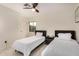 Bright bedroom with two twin beds, sleek nightstand, and a modern ceiling fan at 12821 N 67Th St, Scottsdale, AZ 85254