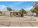 Single story house with white walls, decorative rock feature, and palm tree in front yard at 12821 N 67Th St, Scottsdale, AZ 85254