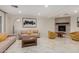 Bright living room featuring light-colored sofas, unique gold chairs, and a fireplace at 12821 N 67Th St, Scottsdale, AZ 85254