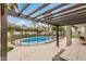 Backyard pool area shaded by a modern pergola, surrounded by lush landscaping at 12821 N 67Th St, Scottsdale, AZ 85254