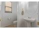 Clean and modern bathroom with pedestal sink and round mirror offering functionality at 13304 W Stella Ln, Litchfield Park, AZ 85340