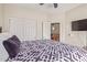 Bedroom featuring a ceiling fan, closet, door to another room, and a TV on the wall at 13304 W Stella Ln, Litchfield Park, AZ 85340