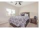 Bright bedroom featuring a ceiling fan, a window, and a cozy bed with drawers for extra storage at 13304 W Stella Ln, Litchfield Park, AZ 85340