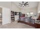 Bedroom featuring a ceiling fan, bookshelves, a television, and a large bed at 13304 W Stella Ln, Litchfield Park, AZ 85340