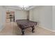 Spacious game room with large pool table, adjacent to an open-concept kitchen area at 13304 W Stella Ln, Litchfield Park, AZ 85340