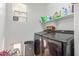 Laundry room with side by side appliances, storage shelves and a small window at 13304 W Stella Ln, Litchfield Park, AZ 85340