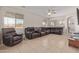Spacious living room with tile flooring, ceiling fan, and ample natural light at 13304 W Stella Ln, Litchfield Park, AZ 85340