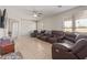 Spacious living room with tile flooring, ceiling fan, and ample natural light at 13304 W Stella Ln, Litchfield Park, AZ 85340