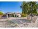 Expansive driveway leads to a covered parking area, complemented by low maintenance gravel landscaping at 1334 W Sells Dr, Phoenix, AZ 85013