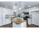 Bright kitchen featuring granite countertops, white cabinetry, stainless steel appliances, and a center island at 1334 W Sells Dr, Phoenix, AZ 85013