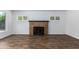 Living room with a brick fireplace, plantation shutters, wood look tile, and white walls at 1334 W Sells Dr, Phoenix, AZ 85013