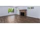 Living room with a wood-burning fireplace, wood-look tile flooring, and bright natural light at 1334 W Sells Dr, Phoenix, AZ 85013