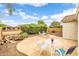 Inviting patio design with lush landscaping, outdoor dining set, and charming fire pit area at 1375 W Belmont Red Trl, San Tan Valley, AZ 85143