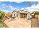 Backyard stone patio with a built-in fire pit, a table with chairs, and some greenery at 1375 W Belmont Red Trl, San Tan Valley, AZ 85143