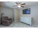 Comfortable bedroom featuring a ceiling fan, TV, dresser, and a cozy recliner chair with lamp at 1375 W Belmont Red Trl, San Tan Valley, AZ 85143