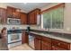 Traditional kitchen with stainless steel appliances, granite countertops and dark wood cabinets at 1375 W Belmont Red Trl, San Tan Valley, AZ 85143