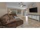 Inviting living room featuring tile floors, a sectional sofa, and a large TV at 1375 W Belmont Red Trl, San Tan Valley, AZ 85143