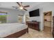 Main bedroom featuring a ceiling fan, TV, walk-in closet, and ensuite bathroom at 1375 W Belmont Red Trl, San Tan Valley, AZ 85143