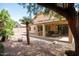 Beautiful backyard with a covered patio, desert landscaping, and mature trees perfect for outdoor living at 1894 E Sagebrush St, Gilbert, AZ 85296