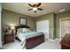 Bedroom with a wooden bed, ceiling fan, and a closet with sliding doors at 20669 N 266Th Ave, Buckeye, AZ 85396