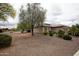 Well-maintained home exterior with desert landscaping and mature trees, offering curb appeal and shade at 20669 N 266Th Ave, Buckeye, AZ 85396