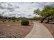 Picturesque golf course view featuring lush greenery, a walking path, and mountain views on a partly cloudy day at 20669 N 266Th Ave, Buckeye, AZ 85396
