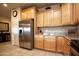 Modern kitchen with stainless steel appliances, wooden cabinets, and granite countertops at 20669 N 266Th Ave, Buckeye, AZ 85396