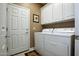 Bright laundry room with white cabinetry, washer, and dryer, providing convenience and functionality at 20669 N 266Th Ave, Buckeye, AZ 85396