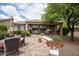 Backyard patio area with brick pavers, desert landscaping, grill, and dining set perfect for gatherings at 20669 N 266Th Ave, Buckeye, AZ 85396