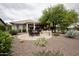 Comfortable outdoor patio with dining table and chairs, manicured landscaping, and a desert aesthetic at 20669 N 266Th Ave, Buckeye, AZ 85396