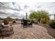 Brick paver patio featuring an outdoor dining set and desert landscaping, perfect for entertaining at 20669 N 266Th Ave, Buckeye, AZ 85396