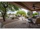 Covered patio features desert landscaping, brick pavers, and outdoor seating, creating an inviting outdoor living space at 20669 N 266Th Ave, Buckeye, AZ 85396