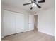 Neutral bedroom featuring a ceiling fan, wood-look flooring, closet and access to the hallway at 2502 S Mollera Cir, Mesa, AZ 85210