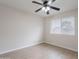 Neutral bedroom featuring a ceiling fan, window and wood-look flooring at 2502 S Mollera Cir, Mesa, AZ 85210