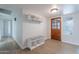 Bright entryway with hardwood floors, a storage bench, and a wooden front door with decorative glass at 2502 S Mollera Cir, Mesa, AZ 85210