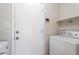 Laundry room with white washer and dryer, storage shelf, and backyard access at 2502 S Mollera Cir, Mesa, AZ 85210