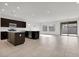 Spacious living room with tile flooring, dark brown kitchen cabinets, and natural light at 2506 N Pony Ln, Casa Grande, AZ 85122